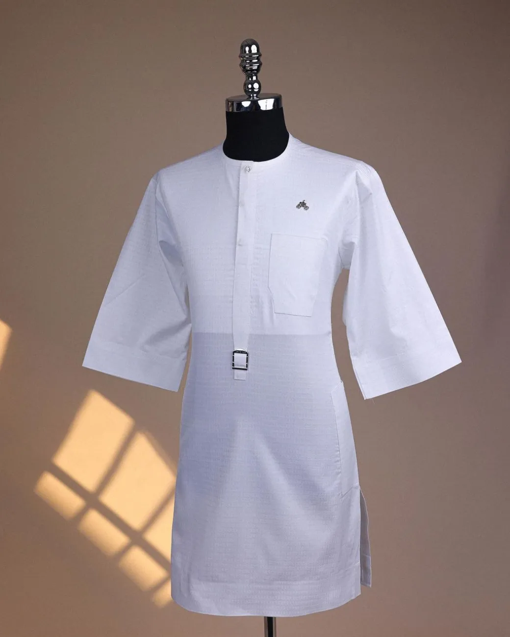 A Bright white, front flap with Swarovski button & metal tag details, 3/4 sleeve African kaftan.