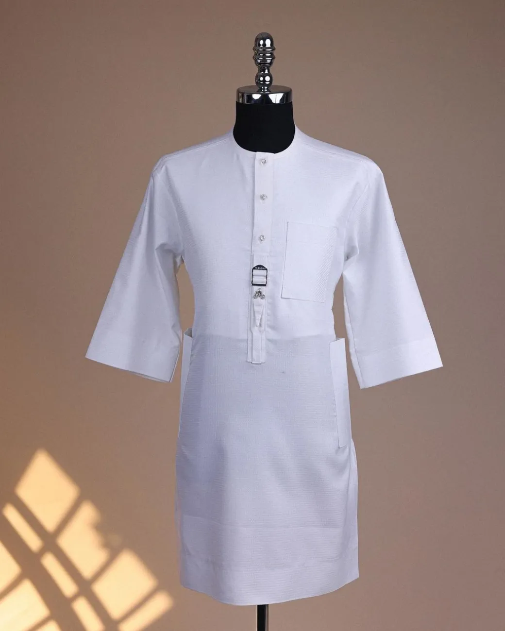 A Bright white, front flap with Swarovski button & metal tag details, 3/4 sleeve African kaftan