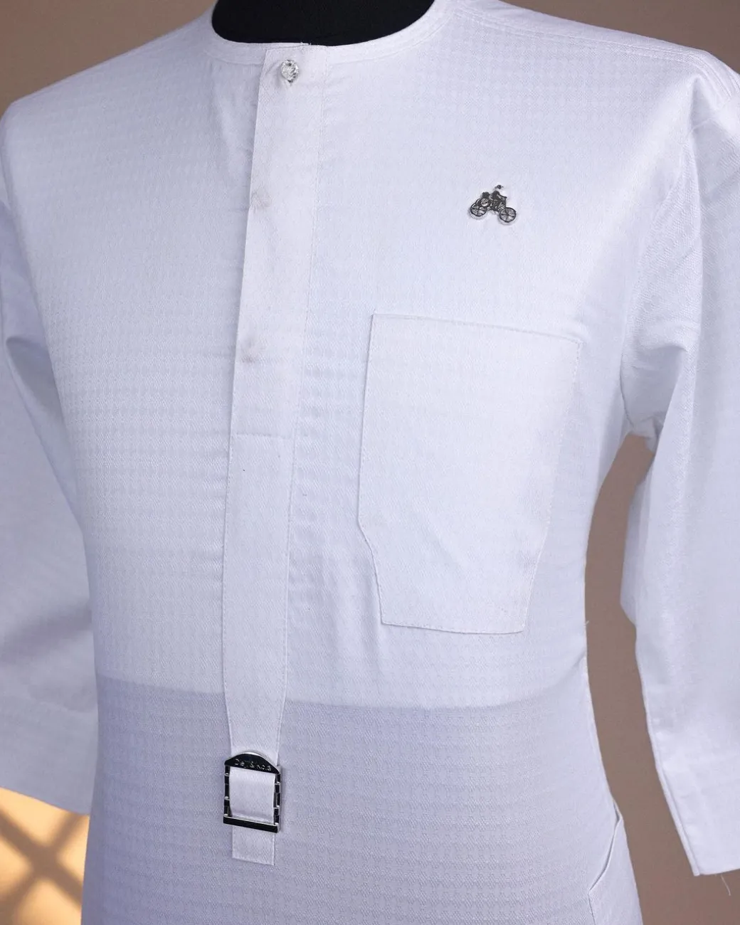 A Bright white, front flap with Swarovski button & metal tag details, 3/4 sleeve African kaftan.