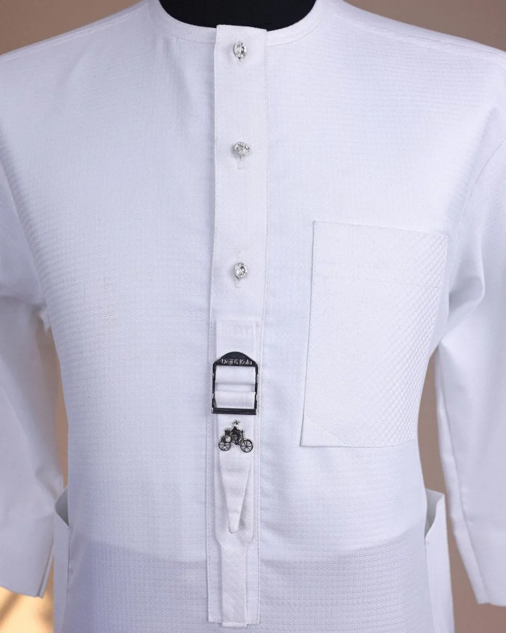 A Bright white, front flap with Swarovski button & metal tag details, 3/4 sleeve African kaftan