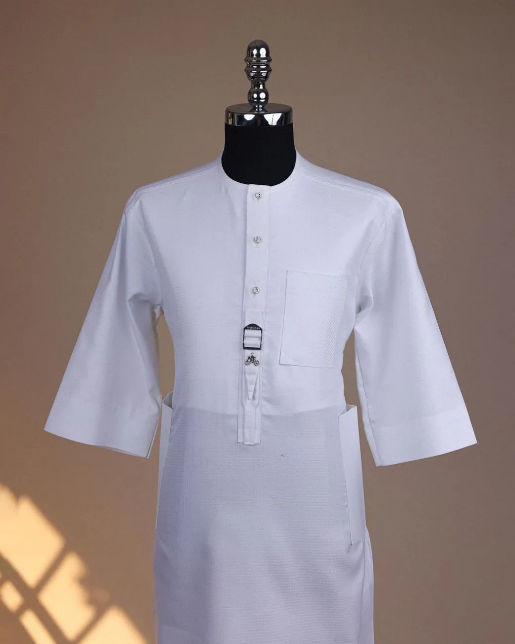 A Bright white, front flap with Swarovski button & metal tag details, 3/4 sleeve African kaftan