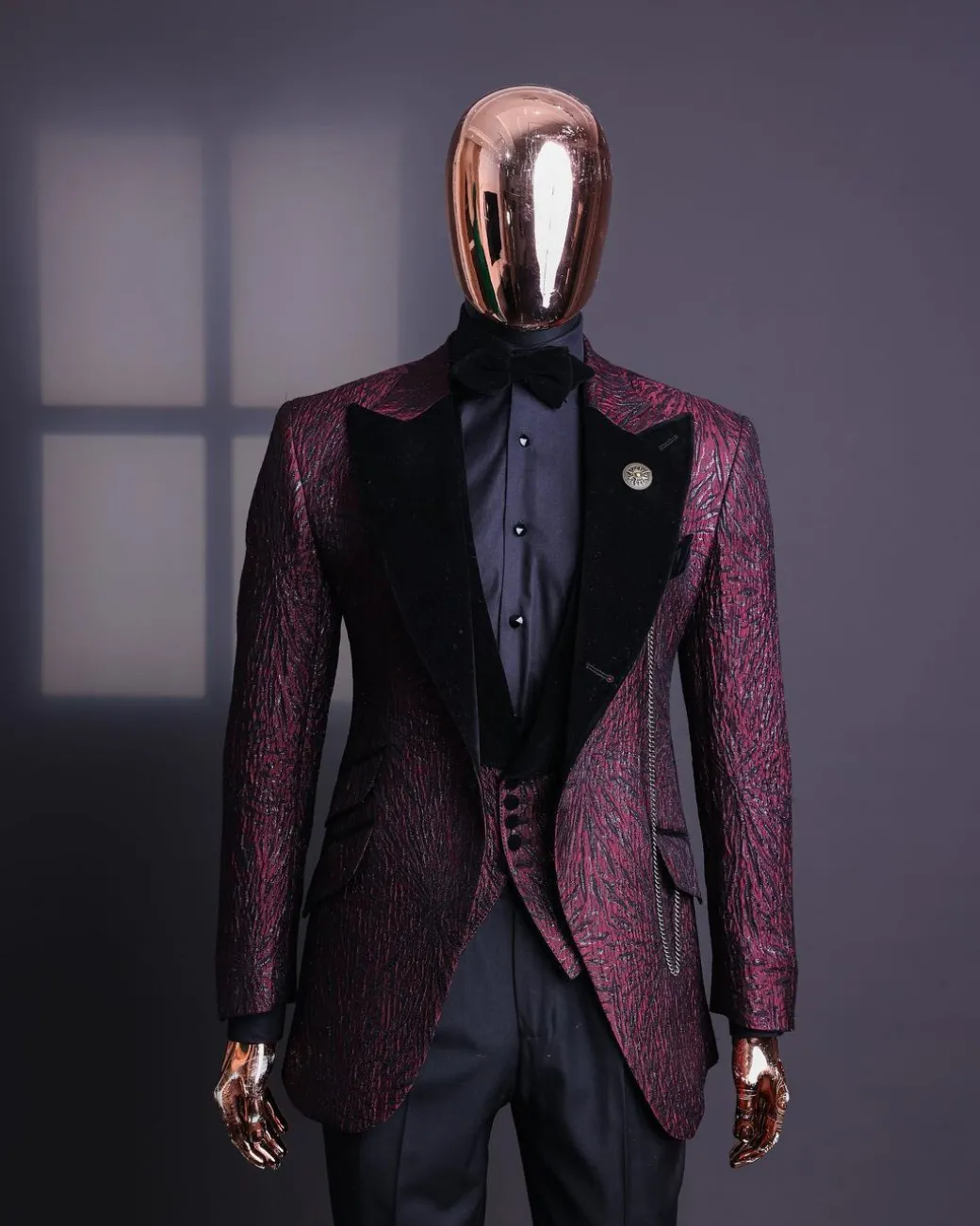 A burgundy, black broom splashed metallic jacquard, knitted, peak lapel tuxedo suit