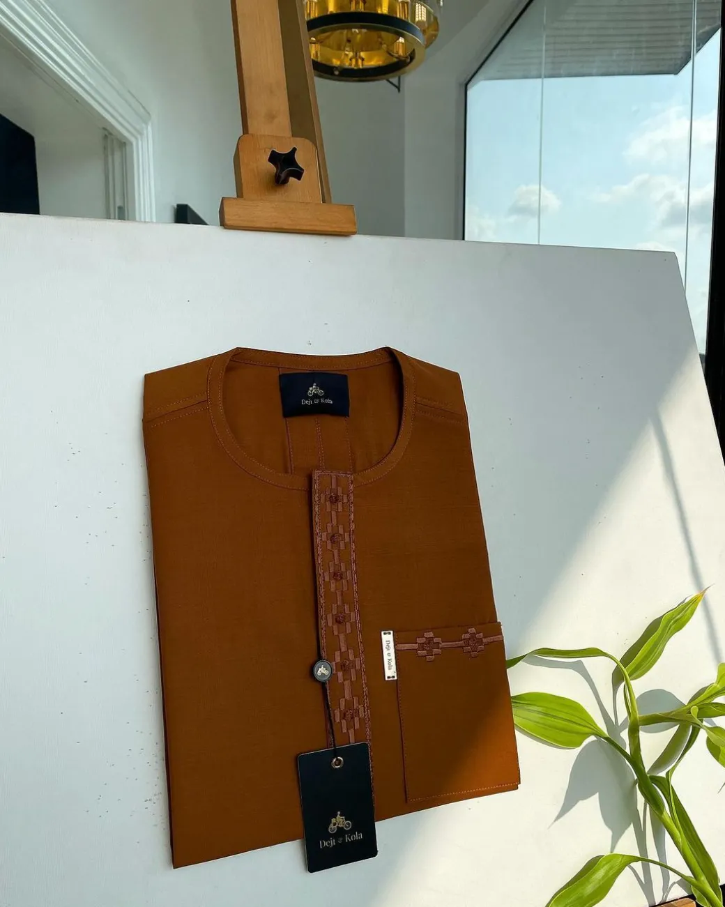 A caramel brown flap and pocket undulating with connected lane embroidery detailing African traditional senator Kaftan native