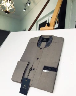 A Carton-colored kaftan with a clear view of black Swarovski button detailing and sokoto