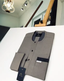A Carton-colored kaftan with a clear view of black Swarovski button detailing and sokoto