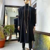 A charcoal black agbada, Jesus piece long fashion chain and hand woven aso oke Yoruba hat.