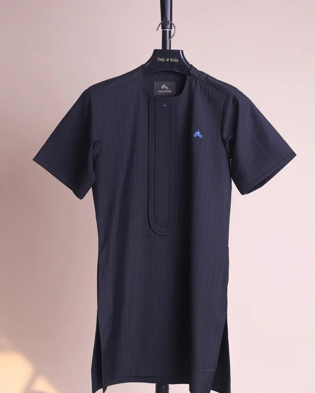 A charcoal black and admiral blue pencil stripe, invisible neckline zip line with layered front flap details, short sleeve African senator kaftan native.