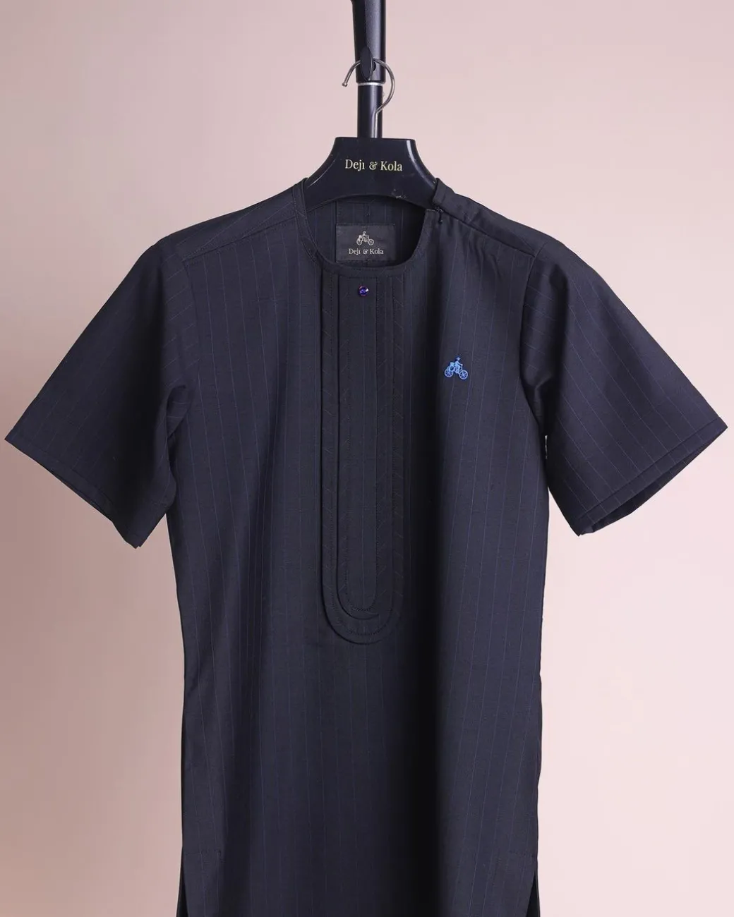 A charcoal black and admiral blue pencil stripe, invisible neckline zip line with layered front flap details, short sleeve African senator kaftan native.