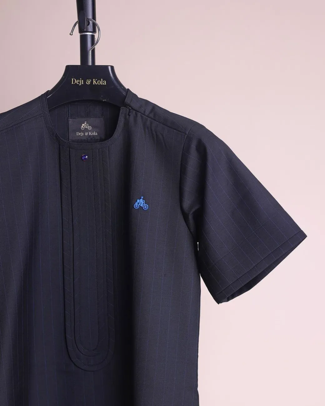 A charcoal black and admiral blue pencil stripe, invisible neckline zip line with layered front flap details, short sleeve African senator kaftan native.