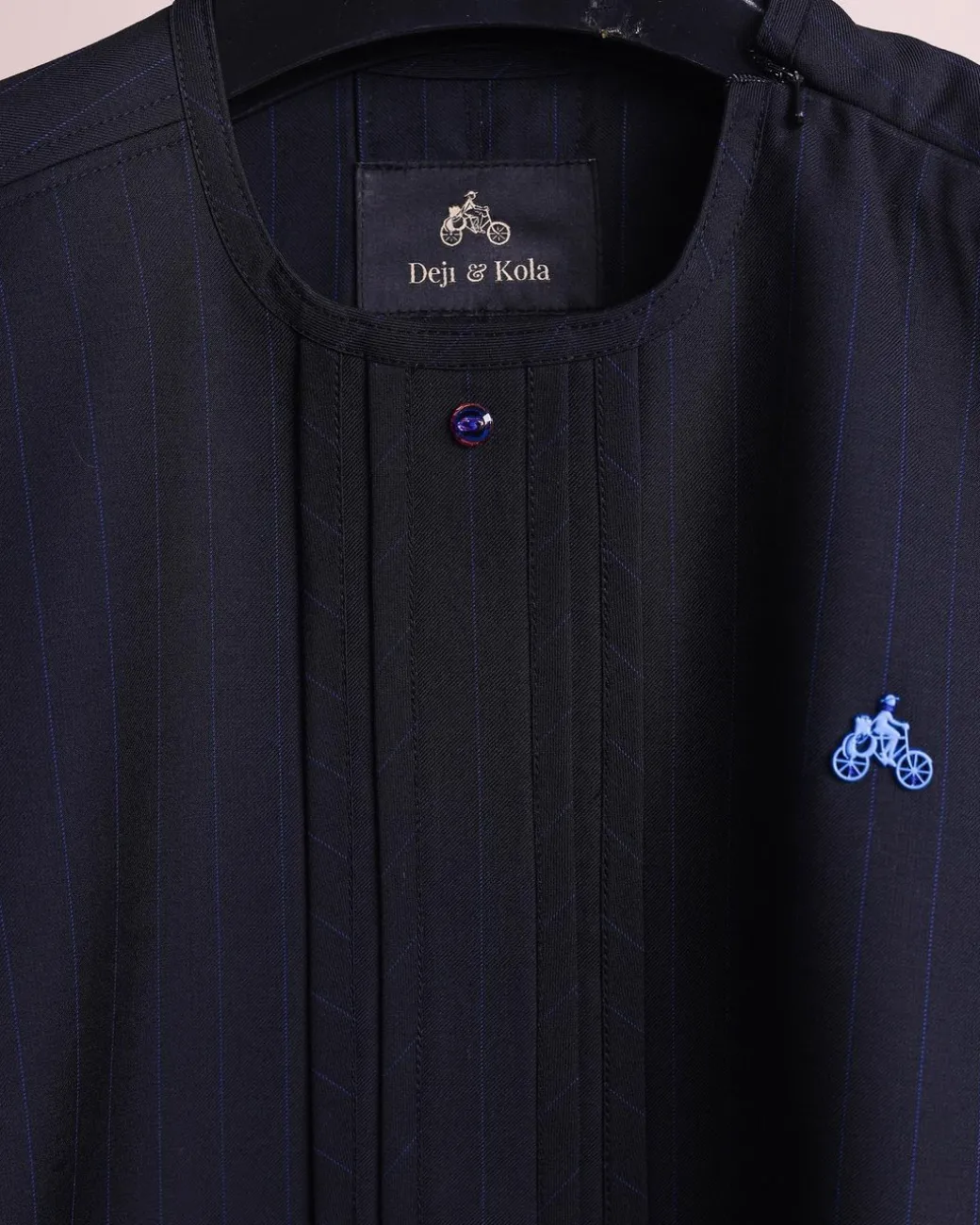 A charcoal black and admiral blue pencil stripe, invisible neckline zip line with layered front flap details, short sleeve African senator kaftan native.