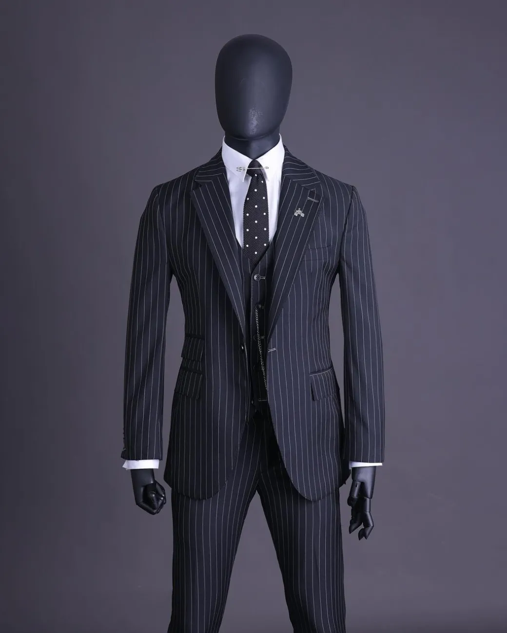 A charcoal black and ivory pencil stripe, notch lapel, knitted one button suit