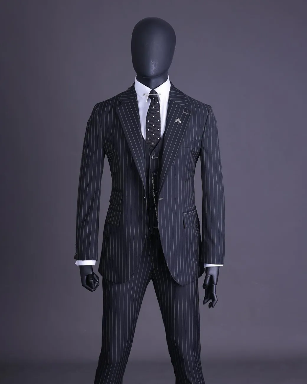 A charcoal black and ivory pencil stripe, notch lapel, knitted one button suit