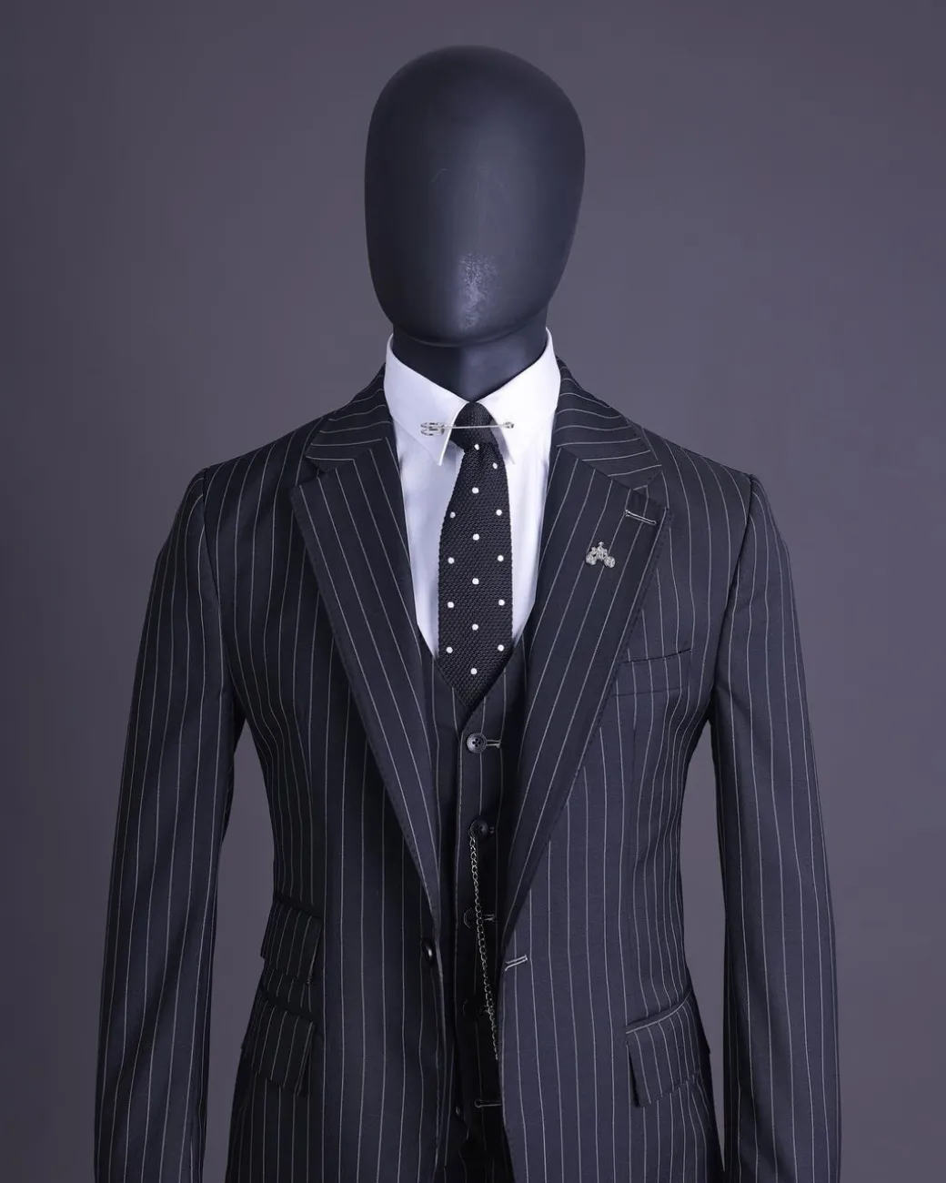 A charcoal black and ivory pencil stripe, notch lapel, knitted one button suit