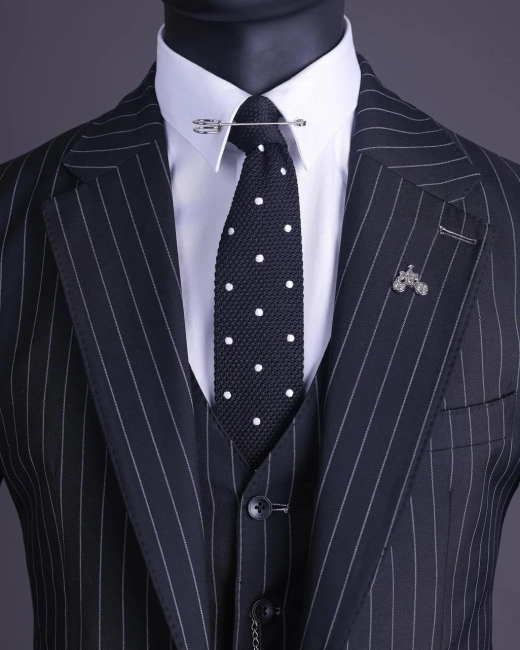 A charcoal black and ivory pencil stripe, notch lapel, knitted one button suit