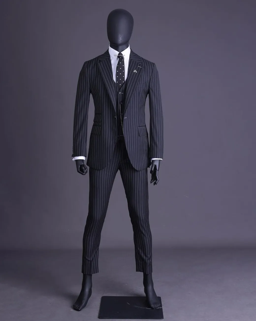 A charcoal black and ivory pencil stripe, notch lapel, knitted one button suit