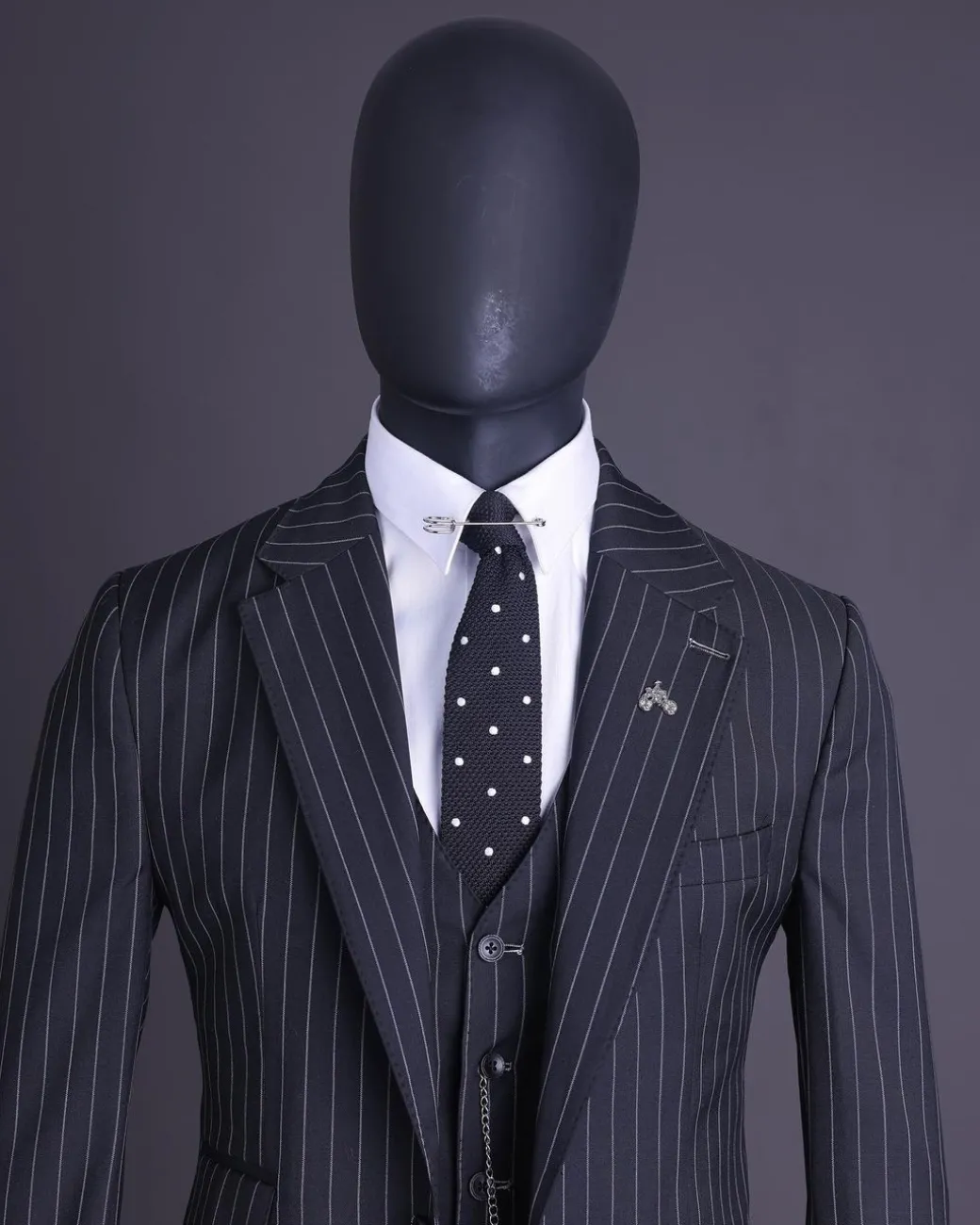 A charcoal black and ivory pencil stripe, notch lapel, knitted one button suit