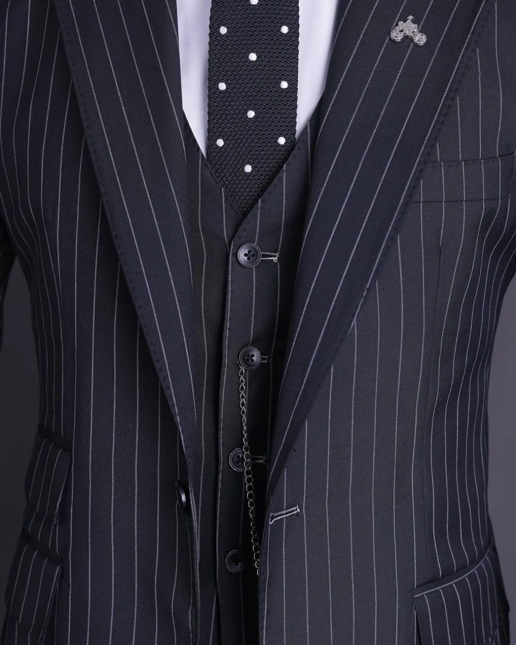A charcoal black and ivory pencil stripe, notch lapel, knitted one button suit