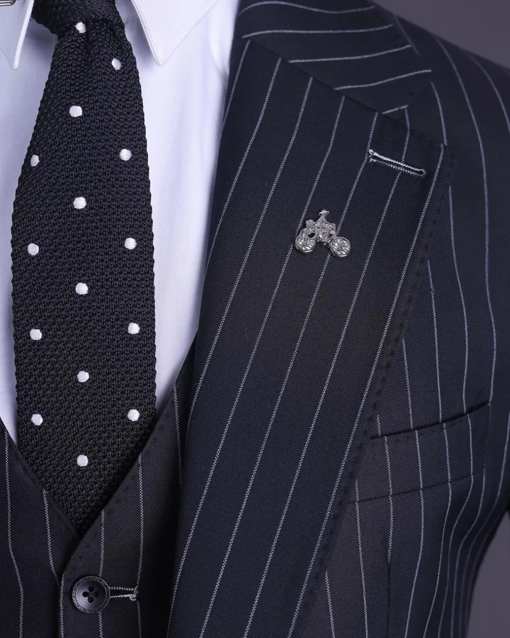 A charcoal black and ivory pencil stripe, notch lapel, knitted one button suit
