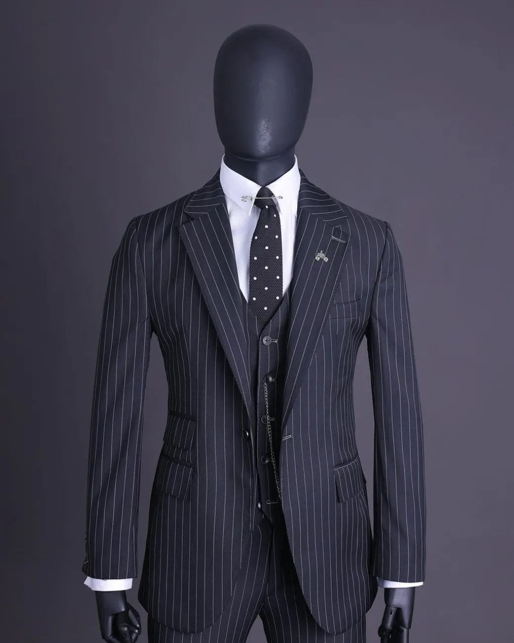 A charcoal black and ivory pencil stripe, notch lapel, knitted one button suit
