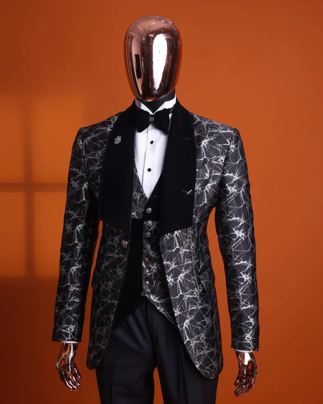 A charcoal black and silver spiral jacquard, shawl lapel tuxedo suit
