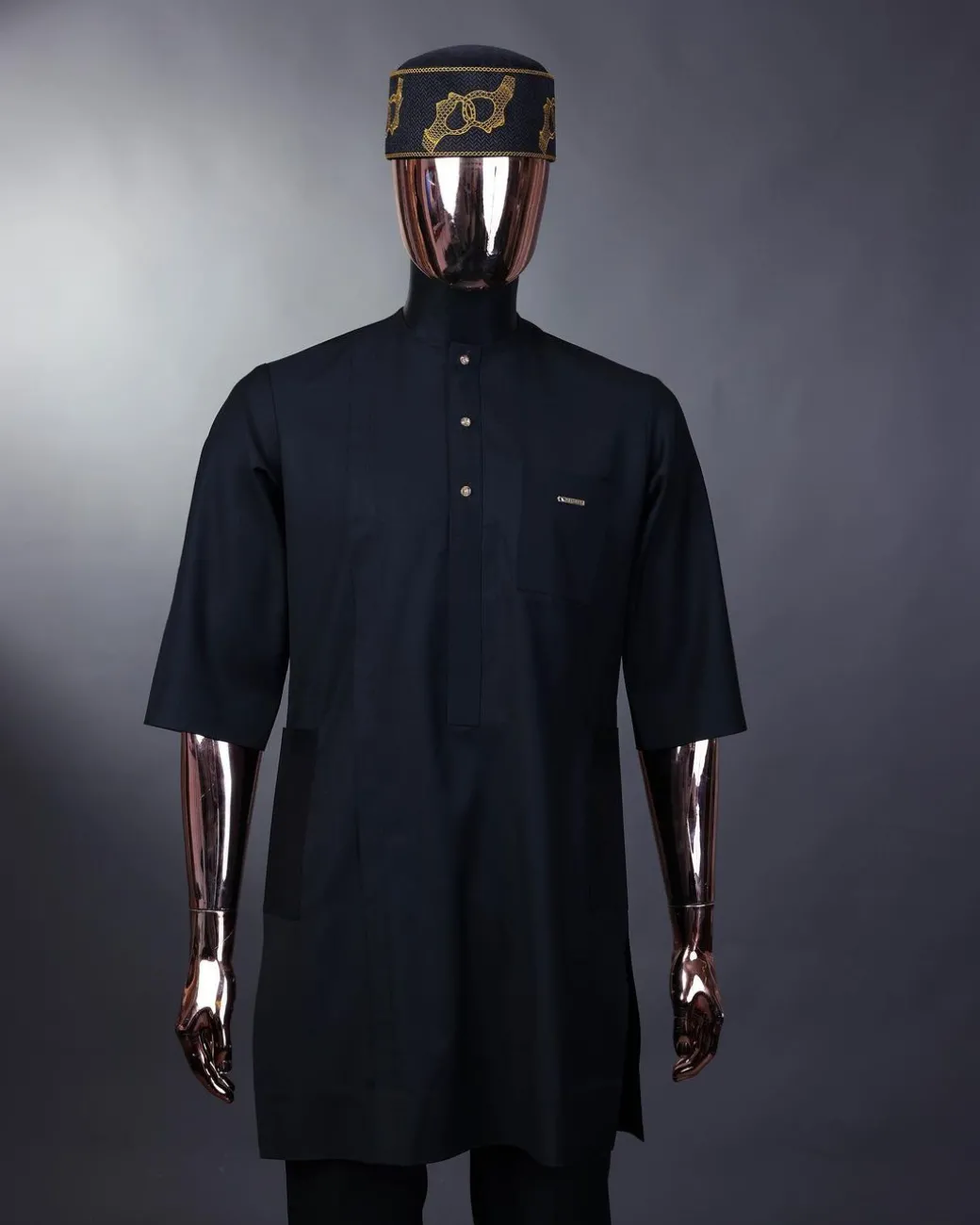 A charcoal black front flap with gold Swarovski buttons, patch pocket, and 3/4 sleeve details African senator kaftan native