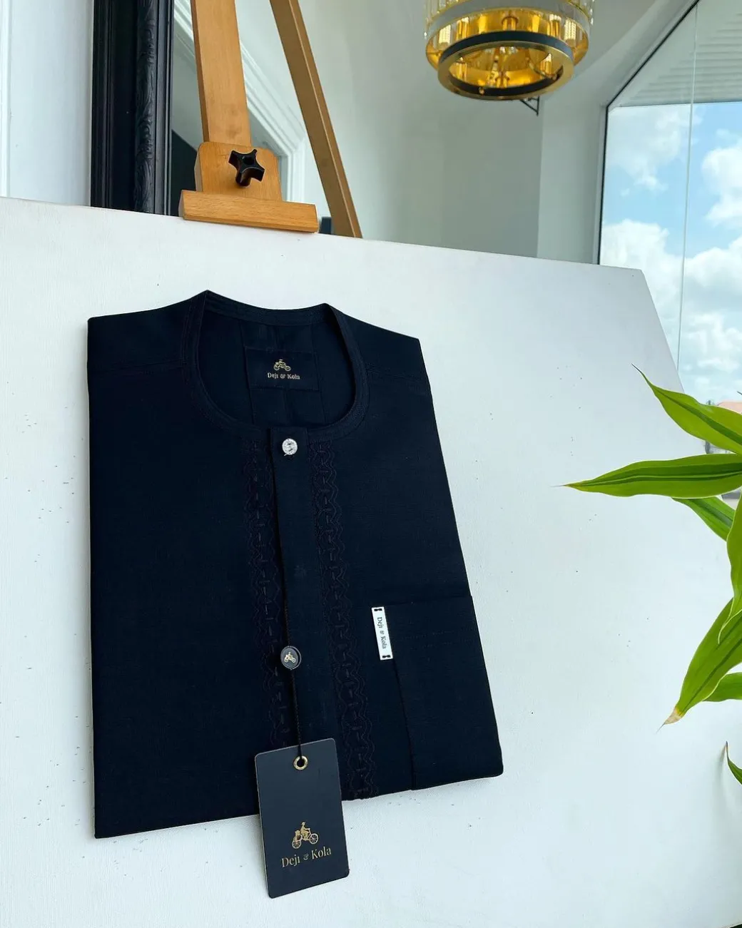 A Charcoal black front flap, interconnected embroidery, and a Swarovski button detail African traditional senator Kaftan native.