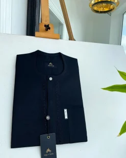 A Charcoal black front flap, interconnected embroidery, and a Swarovski button detail African traditional senator Kaftan native.