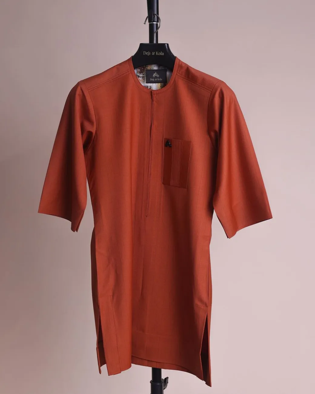 A fire orange and black pencil stripe, zipline, 3/4 sleeve African senator kaftan native.
