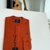 A fire orange, double vertical flap with horizontal closed detailing, combat pocket, and Swarovski button details African traditional senator kaftan native