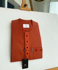 A fire orange, flap and front pocket undulating with connected lane embroidery detailing african traditional senator kaftan native.