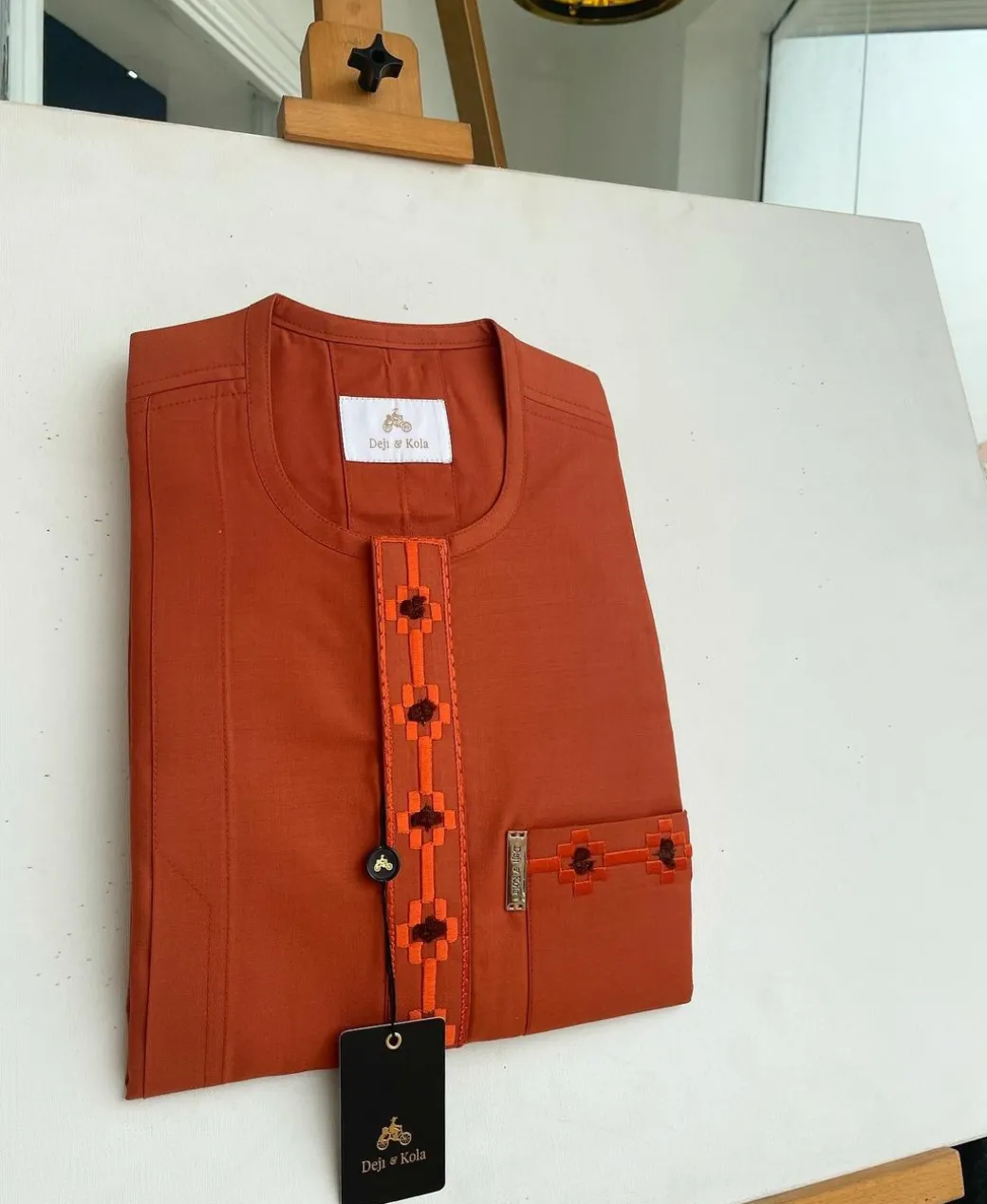 A fire orange, flap and front pocket undulating with connected lane embroidery detailing african traditional senator kaftan native.