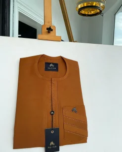 A ginger orange, mid section embrodery front flap with a symmetric lane patch pocket African traditional kaftan native.