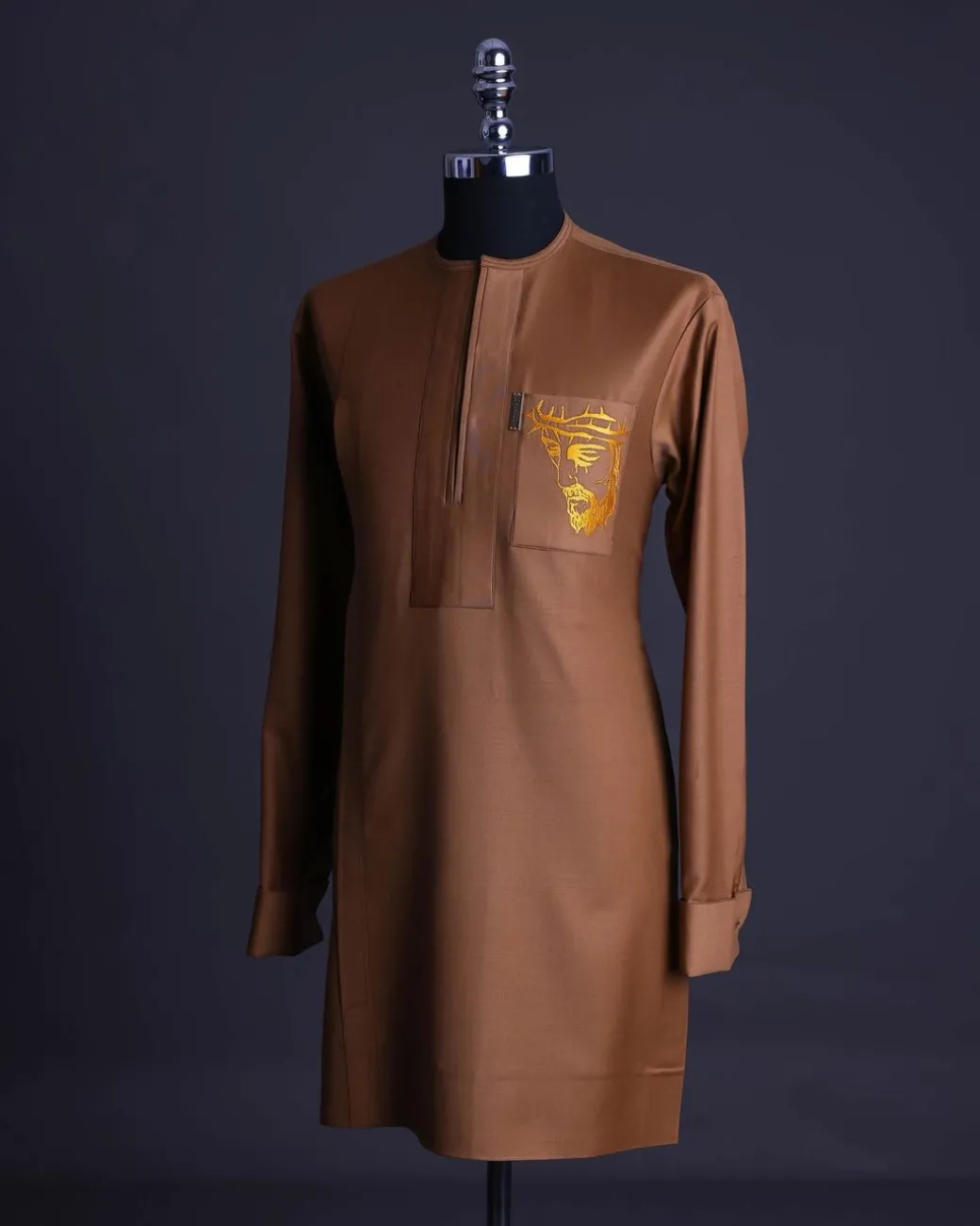 A Gingerbread brown, wide double lane flap, patch pocket with “Golgotha” embroidery detailing African senator kaftan native.