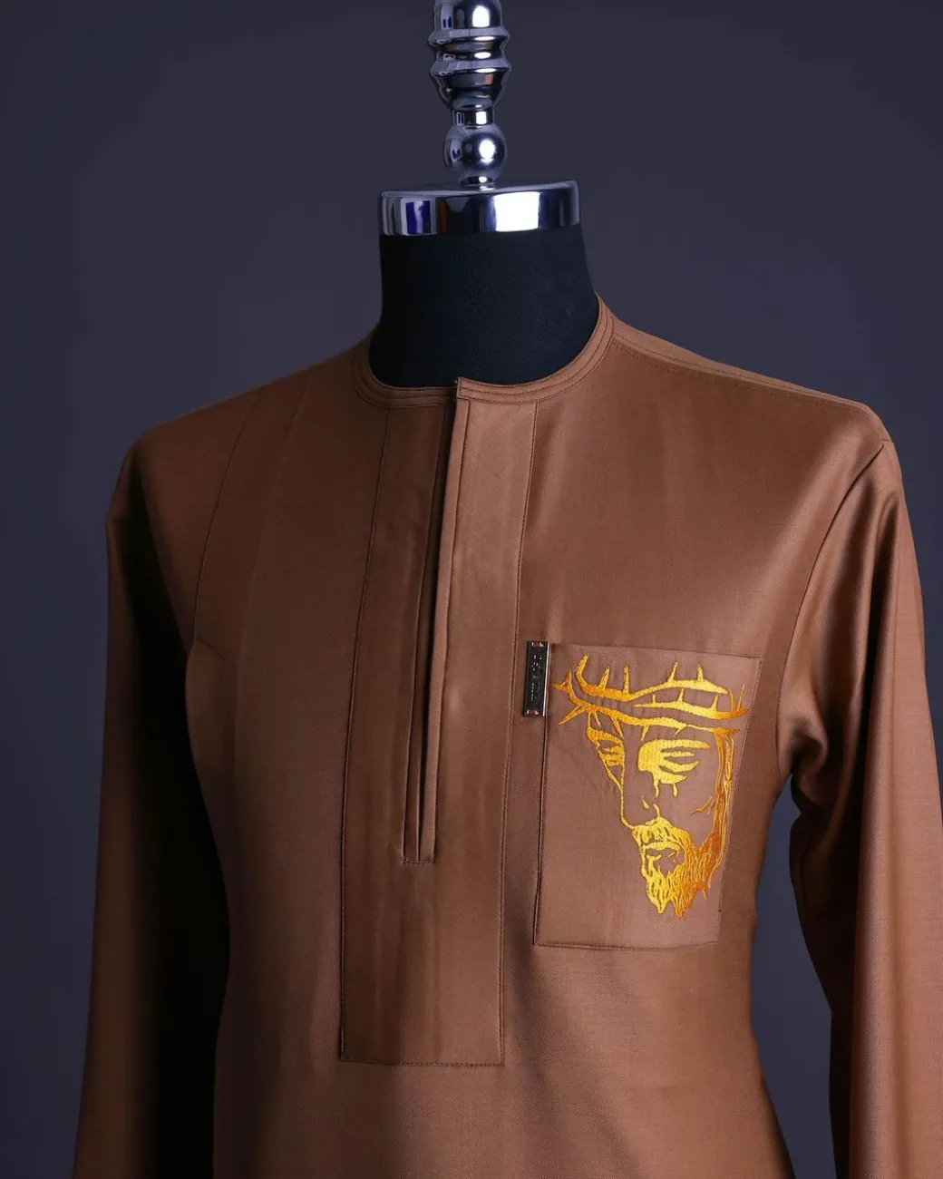 A Gingerbread brown, wide double lane flap, patch pocket with “Golgotha” embroidery detailing African senator kaftan native.