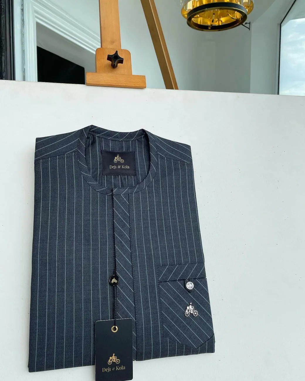 A grey pinstripe kaftan, front Flap with an inverse combat pocket Swarovski button details African traditional senator kaftan native.