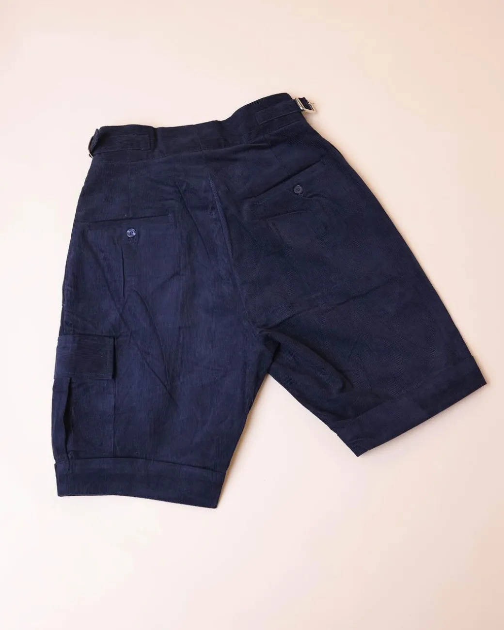 A “Gurkha”pant shorts with pleats, double side strap buckle, combat patch pocket.