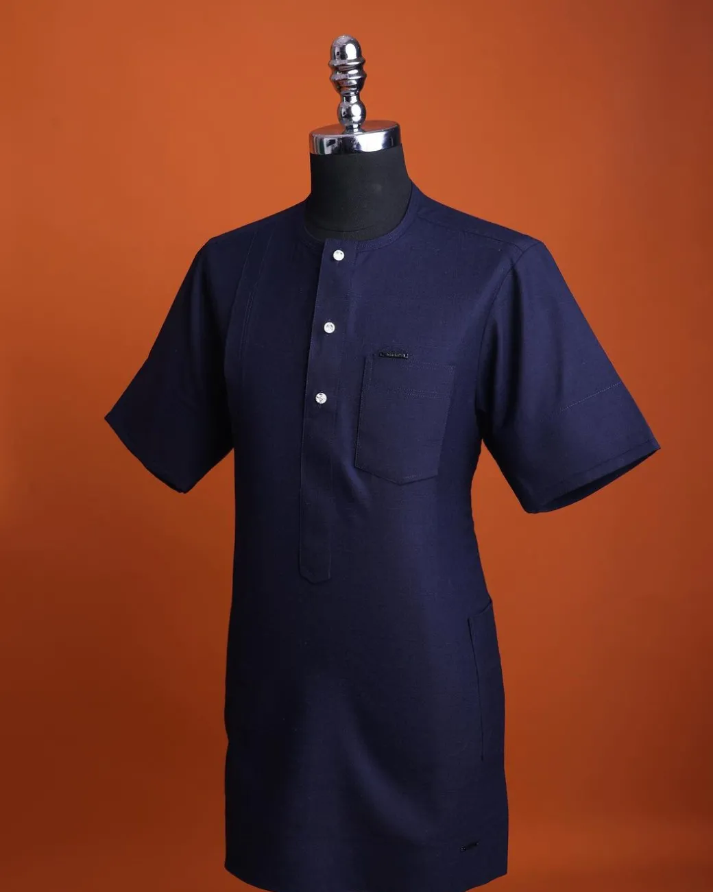A Jorgecarli wool, midnight blue, invisible windowpane check, front flap with silver Swarovski button, shorts sleeve African senator kaftan native.