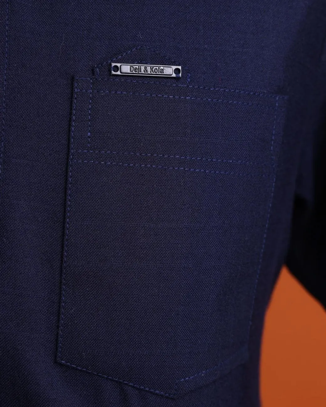 A Jorgecarli wool, midnight blue, invisible windowpane check, front flap with silver Swarovski button, shorts sleeve African senator kaftan native.