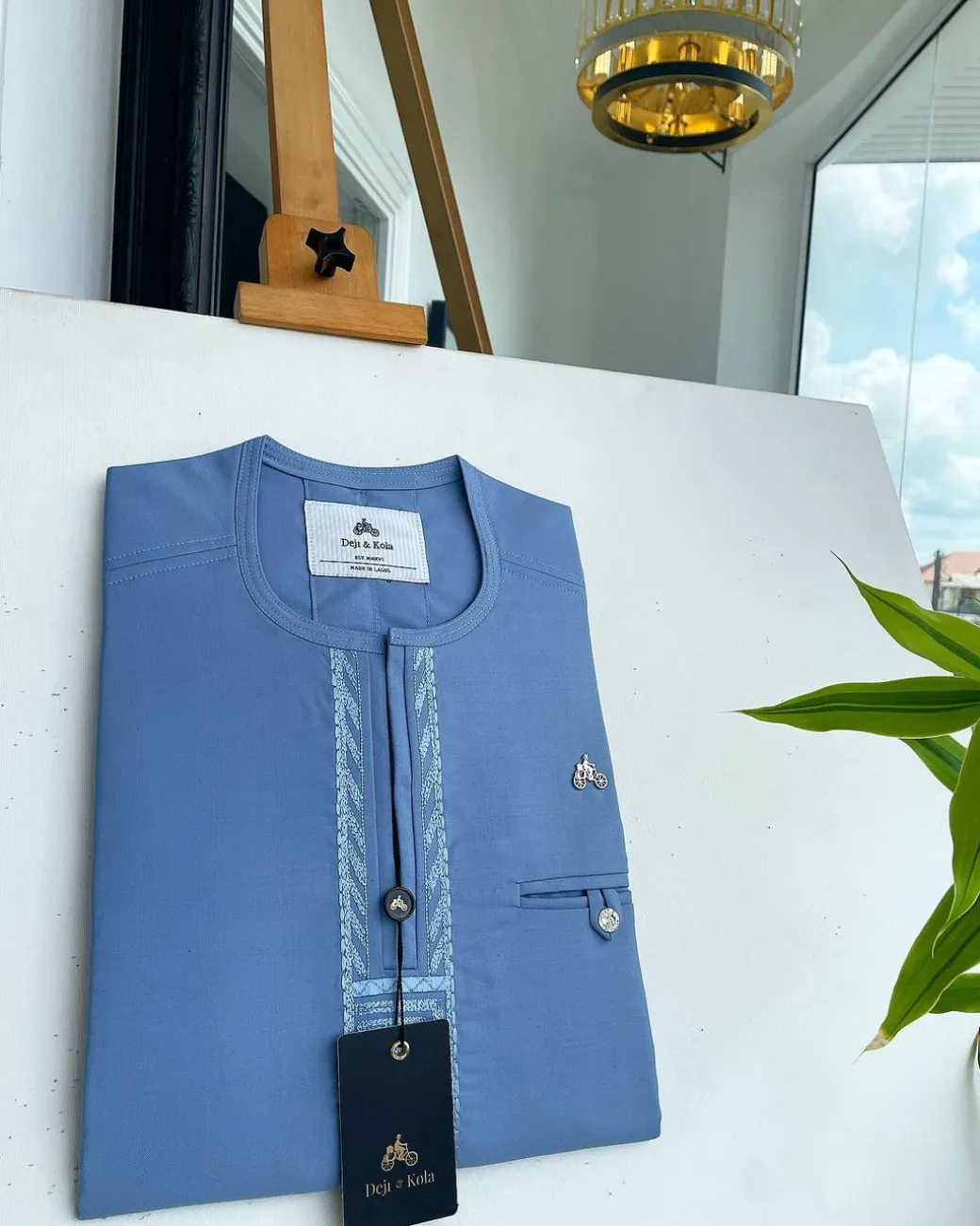 A Maya blue rail line flap with a combat pocket Swarovski button details African traditional senator Kaftan.
