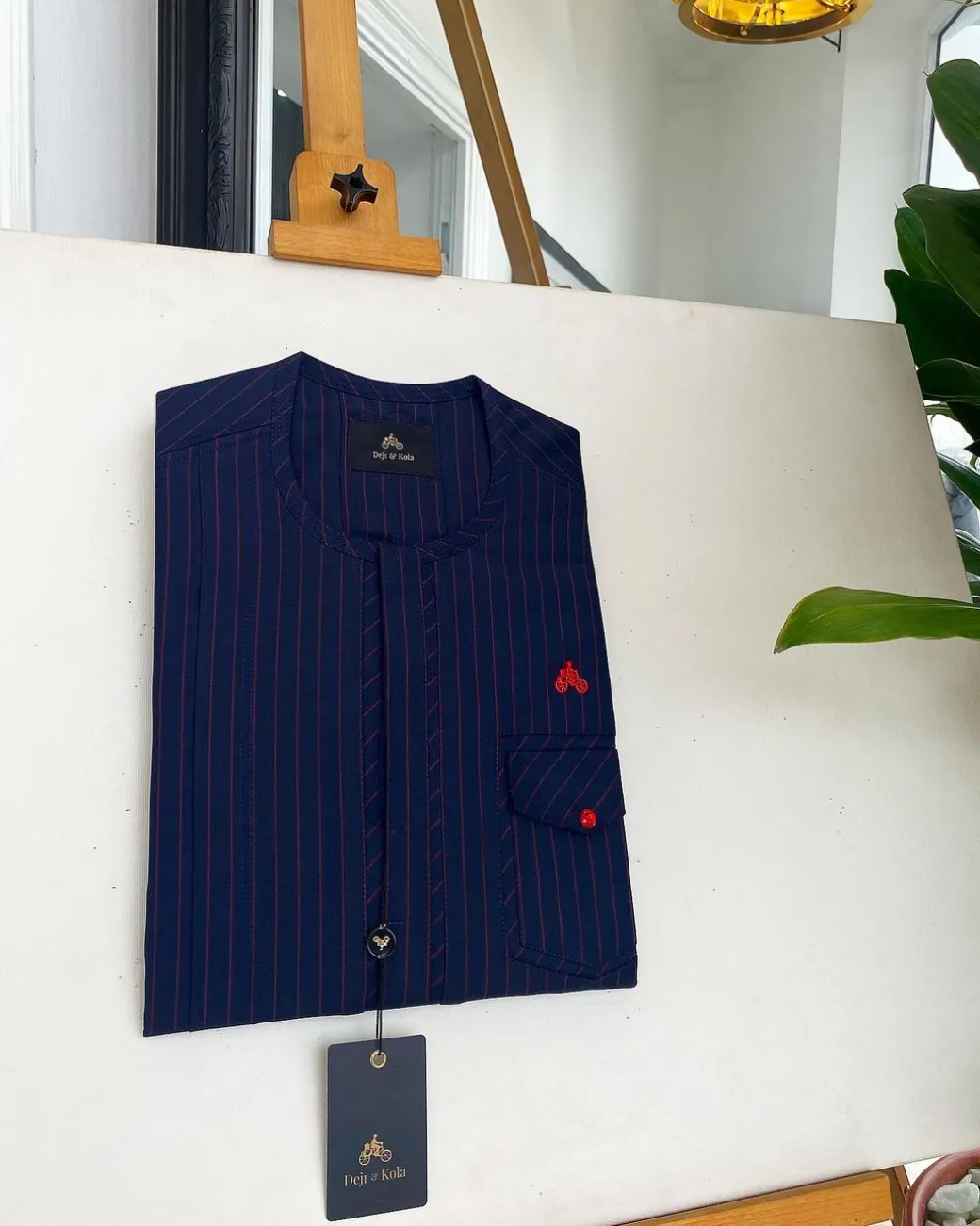 A Midnight Blue and Tomato red Pencil stripe, clear view red Swarovski buttons, front flap, patch pocket details African traditional senator kaftan native.