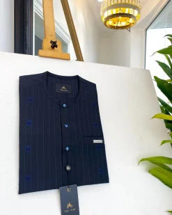 A midnight blue, light blue pencil stripe, clear view Swarovski buttons, horizontal line square embroidery details African traditional senator kaftan native.