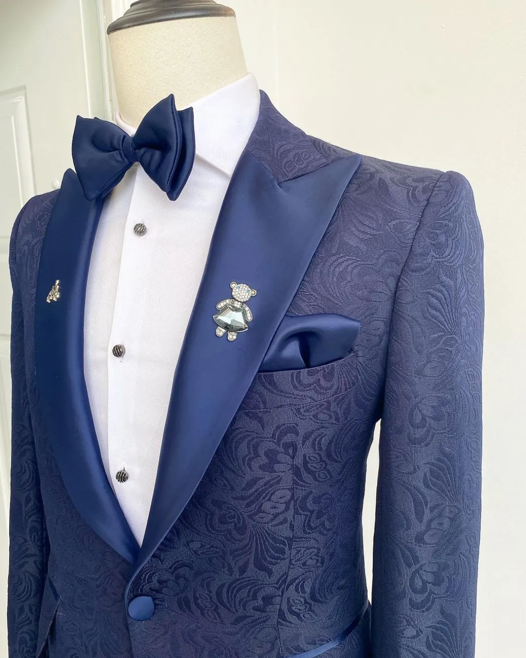 A midnight blue peak lapel floral jacquard tuxedo suit