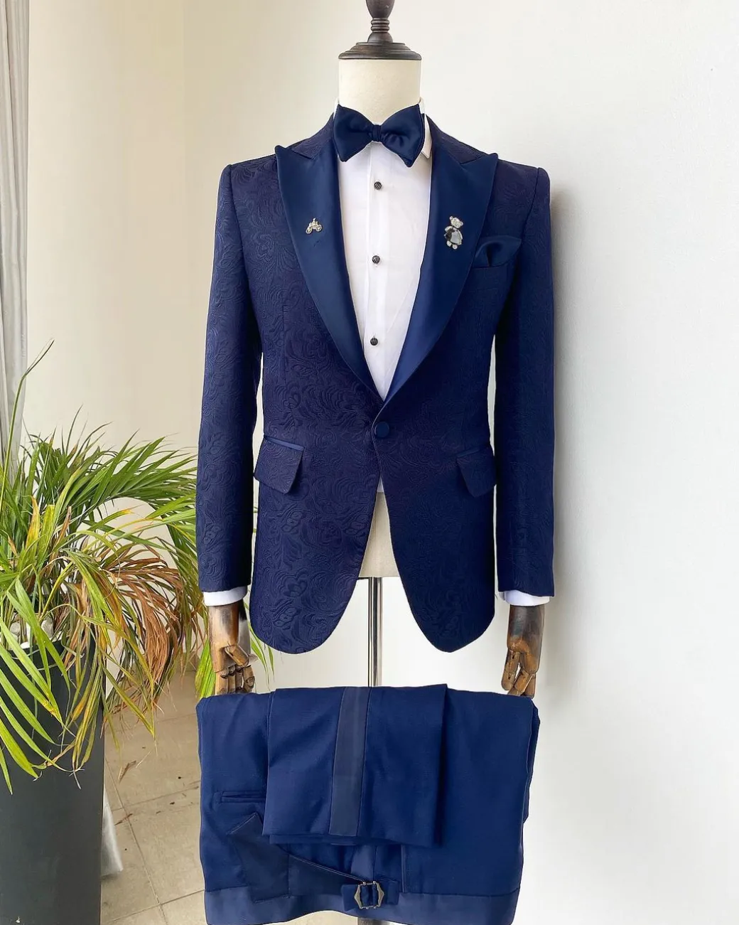 A midnight blue peak lapel floral jacquard tuxedo suit