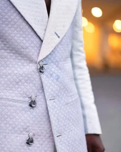 A monochrome, peak lapel, light multi-color dyed trench double breasted jacquard with bunny button details suit