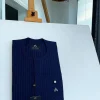 A pencil stripe midnight blue and red front flap with an inverse combat pocket Swarovski button details African traditional senator Kaftan native