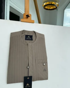 A pencil-striped tortilla brown front flap with an inverse combat pocket Swarovski button details African traditional senator Kaftan native