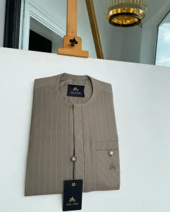 A pencil-striped tortilla brown front flap with an inverse combat pocket Swarovski button details African traditional senator Kaftan native