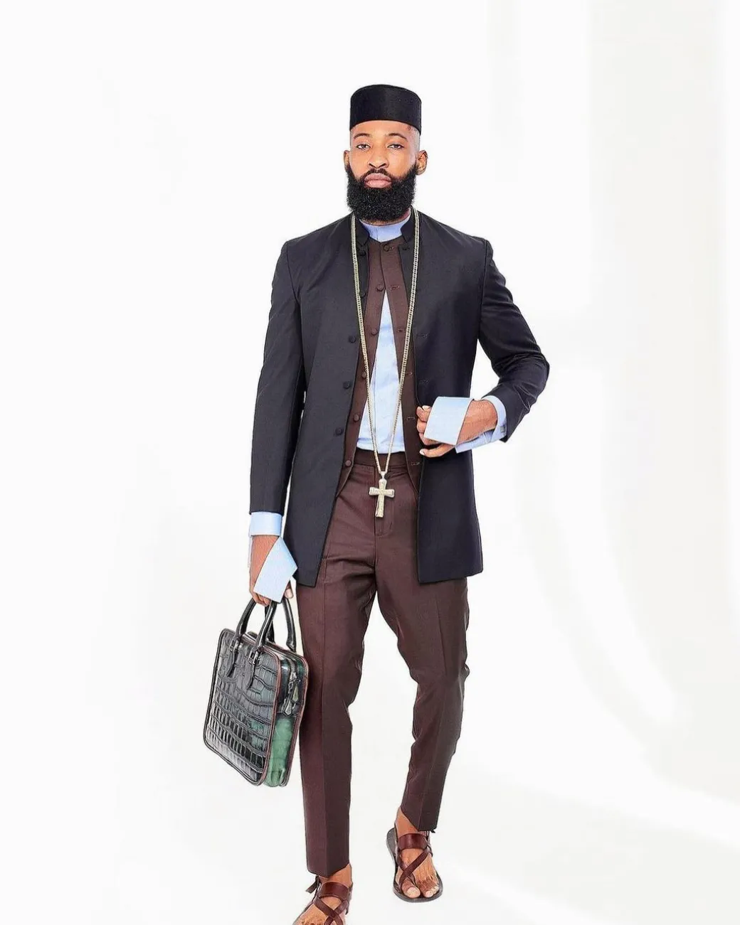 A Reloaded Ceremonial “Ayeye” Ijade 20/21 – Look 10- “Ajala”. A burgundy safari jacket with gold buttons, inner waist coat, turtle neck shirt, hat and pant trousers.