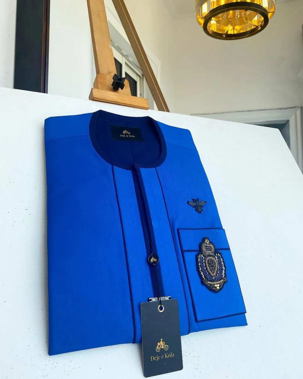 A Royal blue with navy blue mix, hand embroidery patch detailing, and black butterfly metal lapel African Kaftan