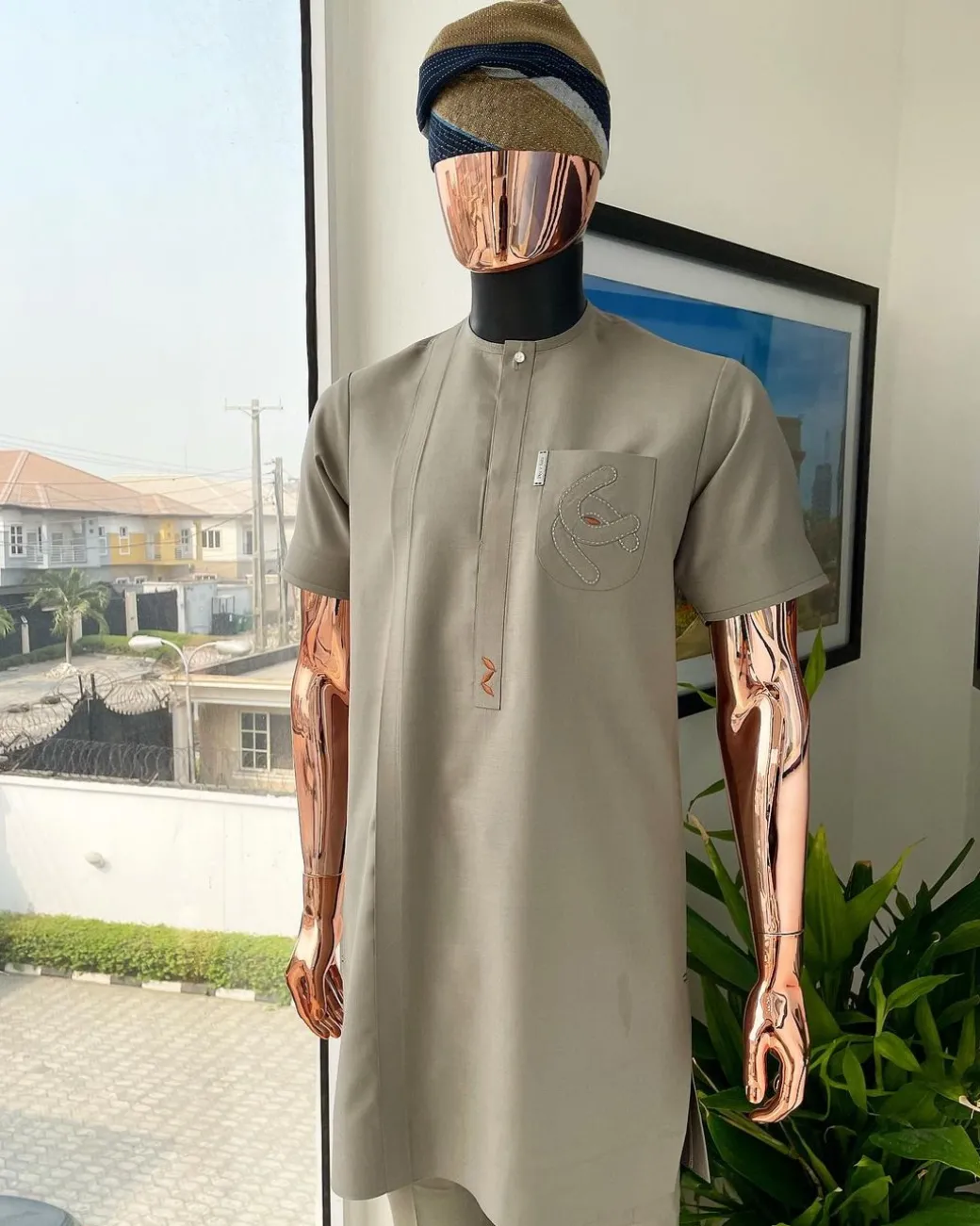 A Sand dollar beige, clear view Swarovski button with orange embroidery flap and pocket detailing African traditional senator kaftan native.